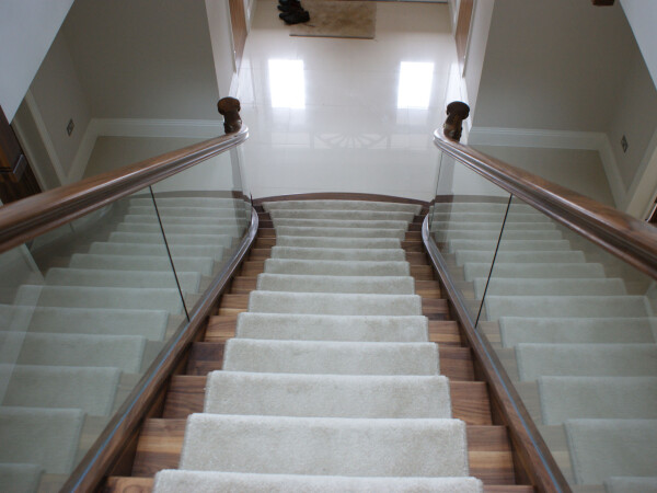 a view of looking down the staircase with glass balustrade